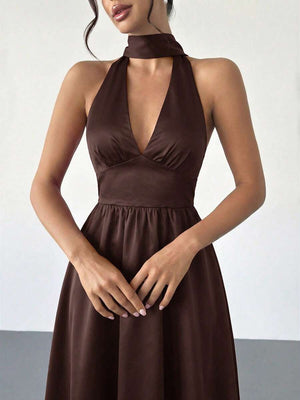 Vista completa de una mujer luciendo un vestido halter sofisticado con zapatos nude.