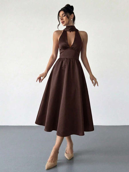Mujer elegante posando con un vestido halter midi de satén color marrón.