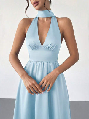 Look completo con vestido midi celeste de cuello halter combinado con tacones nude.