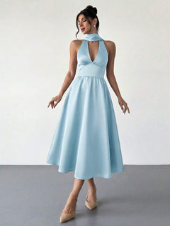 Mujer modelando un vestido midi elegante color celeste con cuello halter y falda A.