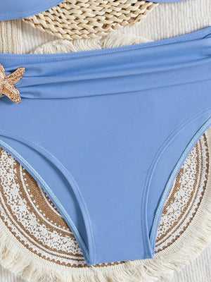 Detalle de estrella dorada en bikini azul elegante.