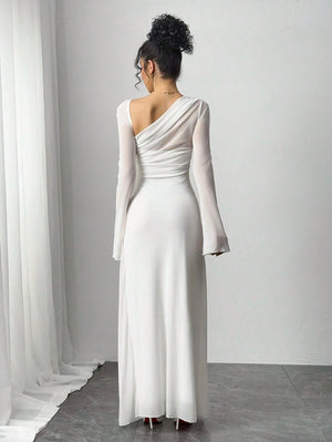 Primer plano del torso de una mujer con un vestido blanco de un solo hombro con detalles de malla transparente.