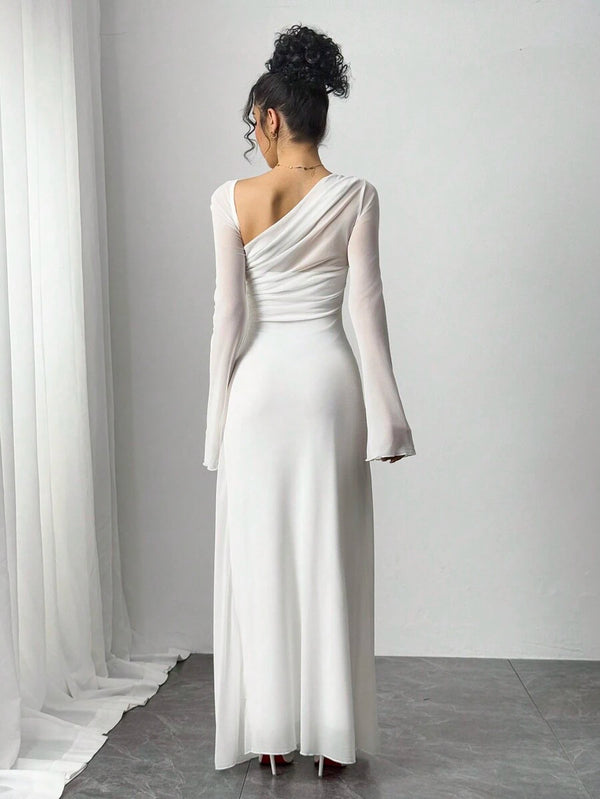 Primer plano del torso de una mujer con un vestido blanco de un solo hombro con detalles de malla transparente.