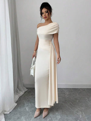 Mujer posando de lado para mostrar la silueta del vestido corte sirena en color crema.