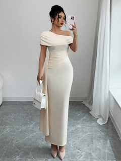Vista completa de mujer vistiendo un vestido largo de fiesta color crema con escote asimétrico y drapeado lateral.