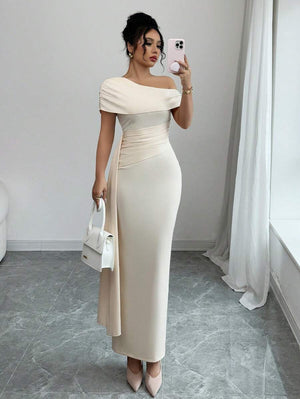 Vista completa de mujer vistiendo un vestido largo de fiesta color crema con escote asimétrico y drapeado lateral.