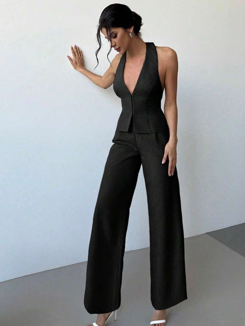 Mujer modelando un conjunto elegante de dos piezas en color negro, compuesto por un chaleco con escote halter y pantalón de pierna ancha.