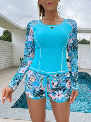 Detalle del torso de un top de baño tipo rash guard color turquesa con costuras blancas.