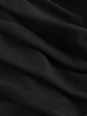 Detalle de la parte inferior del vestido midi negro, mostrando el efecto del fruncido en la tela.