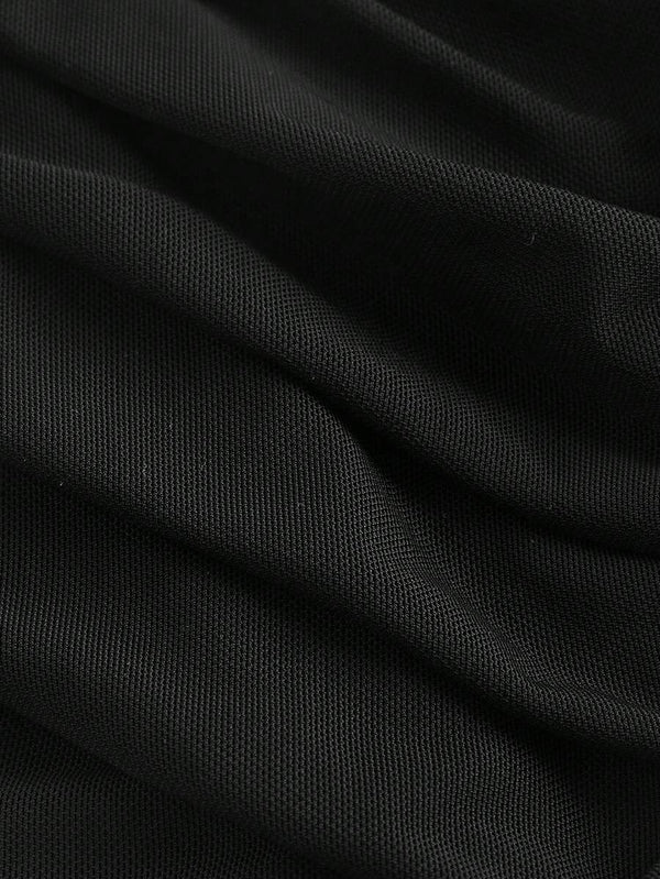 Detalle de la parte inferior del vestido midi negro, mostrando el efecto del fruncido en la tela.