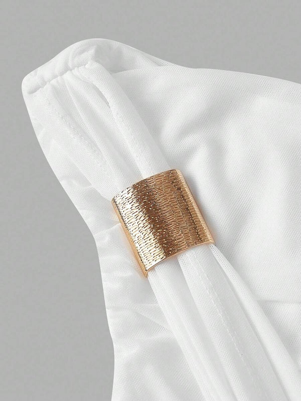 Primer plano de la parte superior de un vestido blanco de un solo hombro con fruncido.