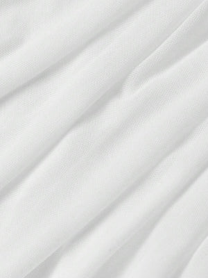 Vista del drapeado en la falda de un vestido blanco ajustado.