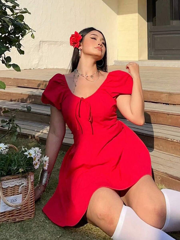 Perfil de una mujer luciendo un vestido rojo de estilo romántico bajo el sol.