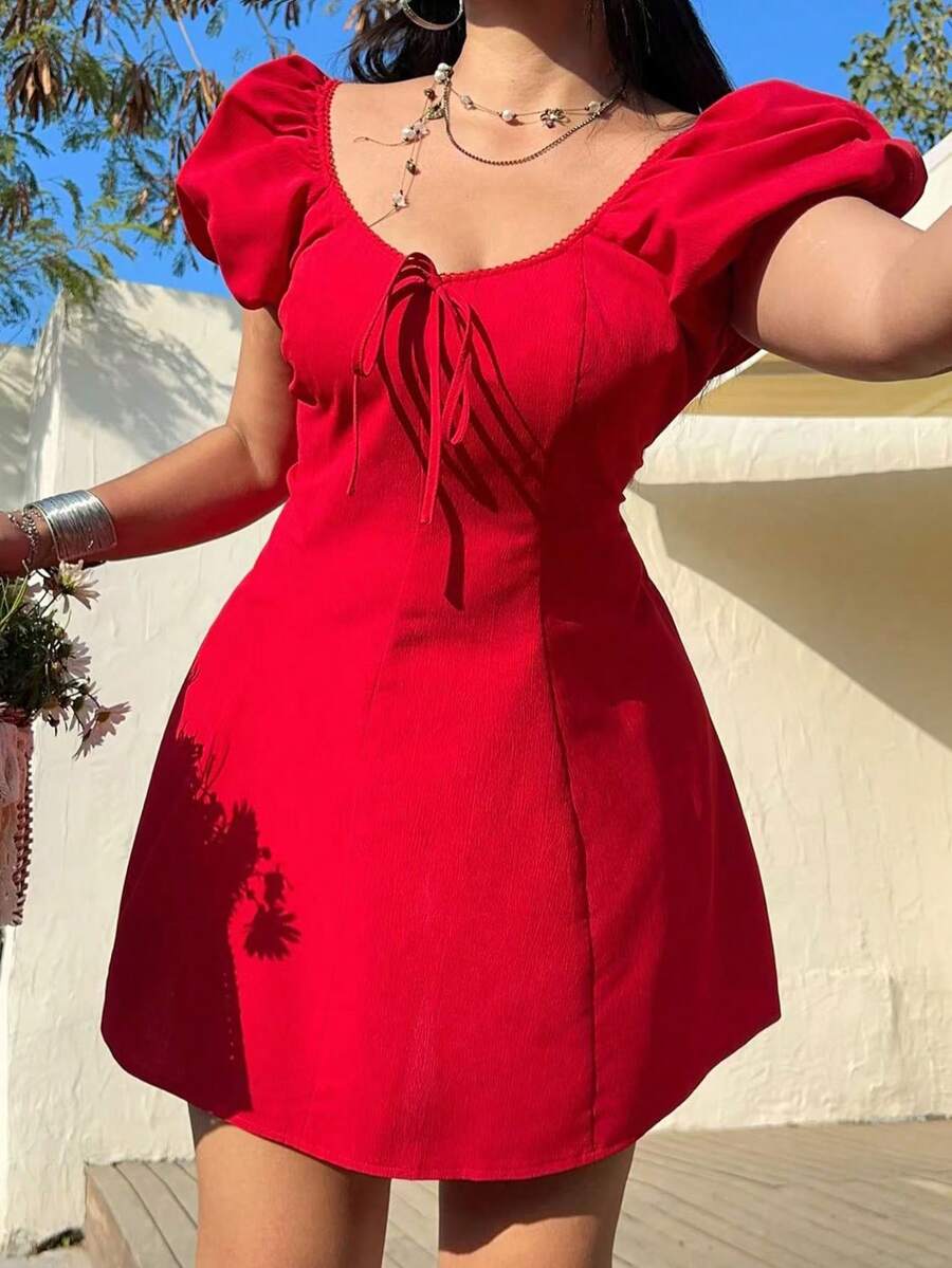 Vista completa de un vestido rojo corto con mangas abullonadas y lazo en el escote.