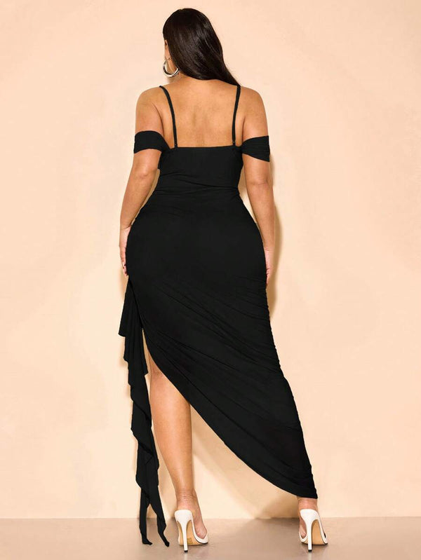 Primer plano del torso de una mujer con un vestido negro de escote cuadrado y tirantes finos.
