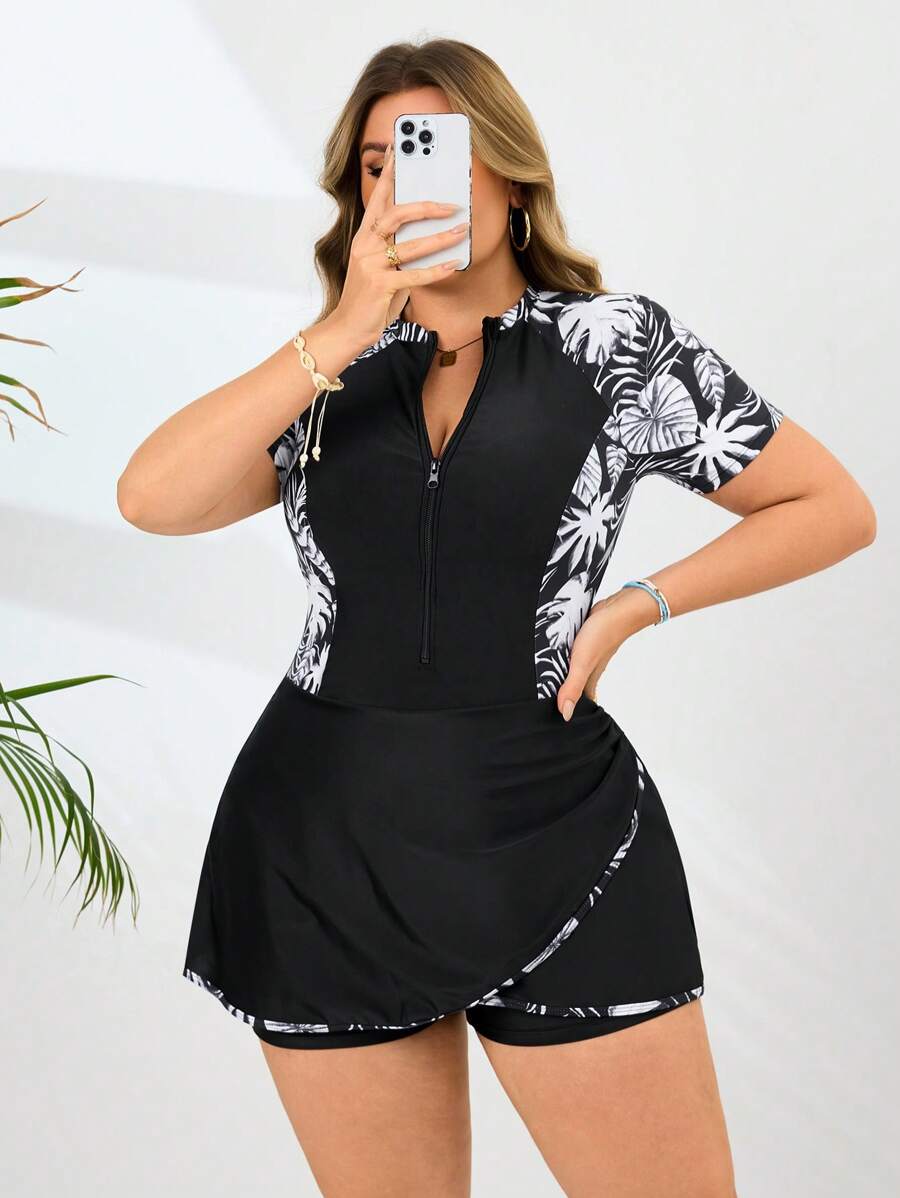 Mujer posando con traje de baño enterizo negro con estampado floral y falda