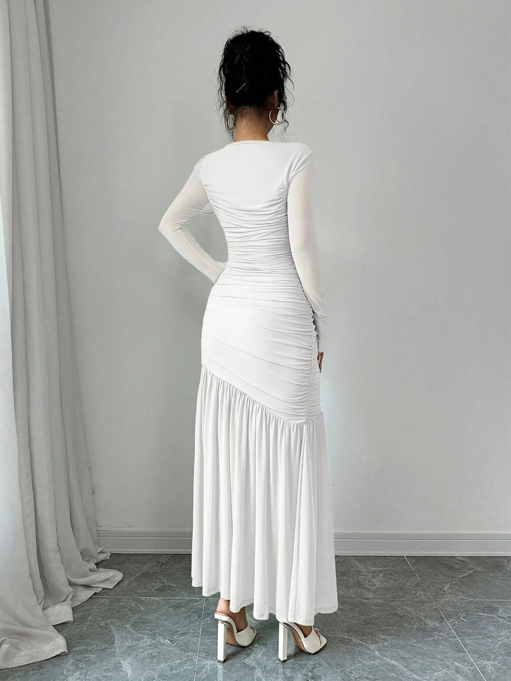 Vestido elegante blanco largo ajustado con fruncido frontal.