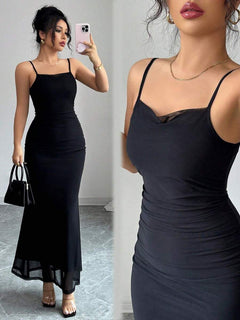 Mujer con vestido largo negro ajustado estilo sirena posando frente a un espejo.