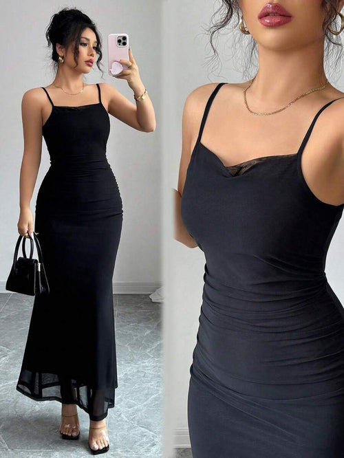 Mujer con vestido largo negro ajustado estilo sirena posando frente a un espejo.