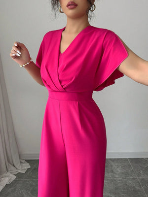 Detalle del escote y mangas del jumpsuit rosa fucsia.