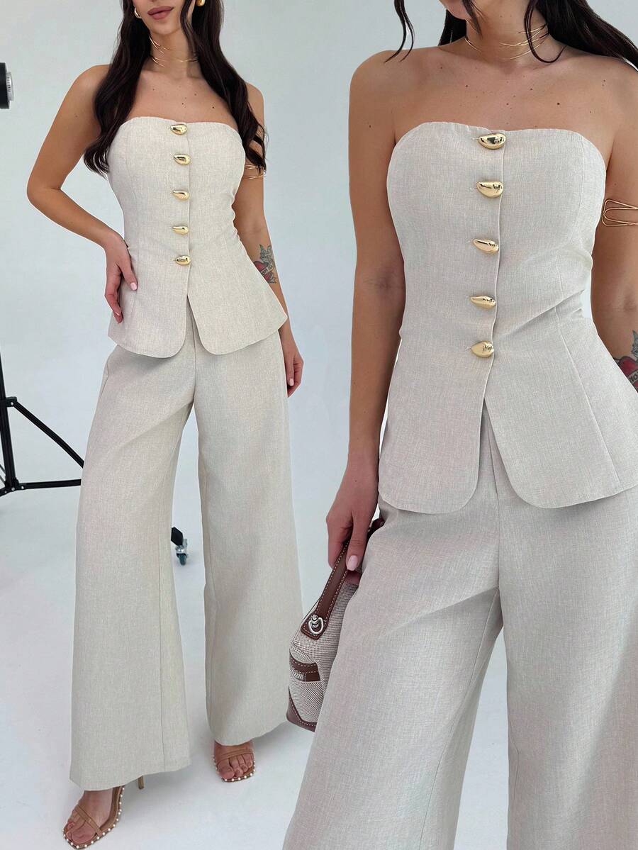 Vista completa de conjunto elegante de dos piezas color beige con top strapless y pantalón de pierna ancha.