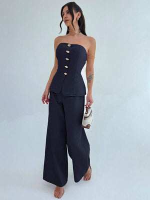 Silueta completa de una mujer vistiendo un conjunto formal de top sin tirantes y pantalón ancho.