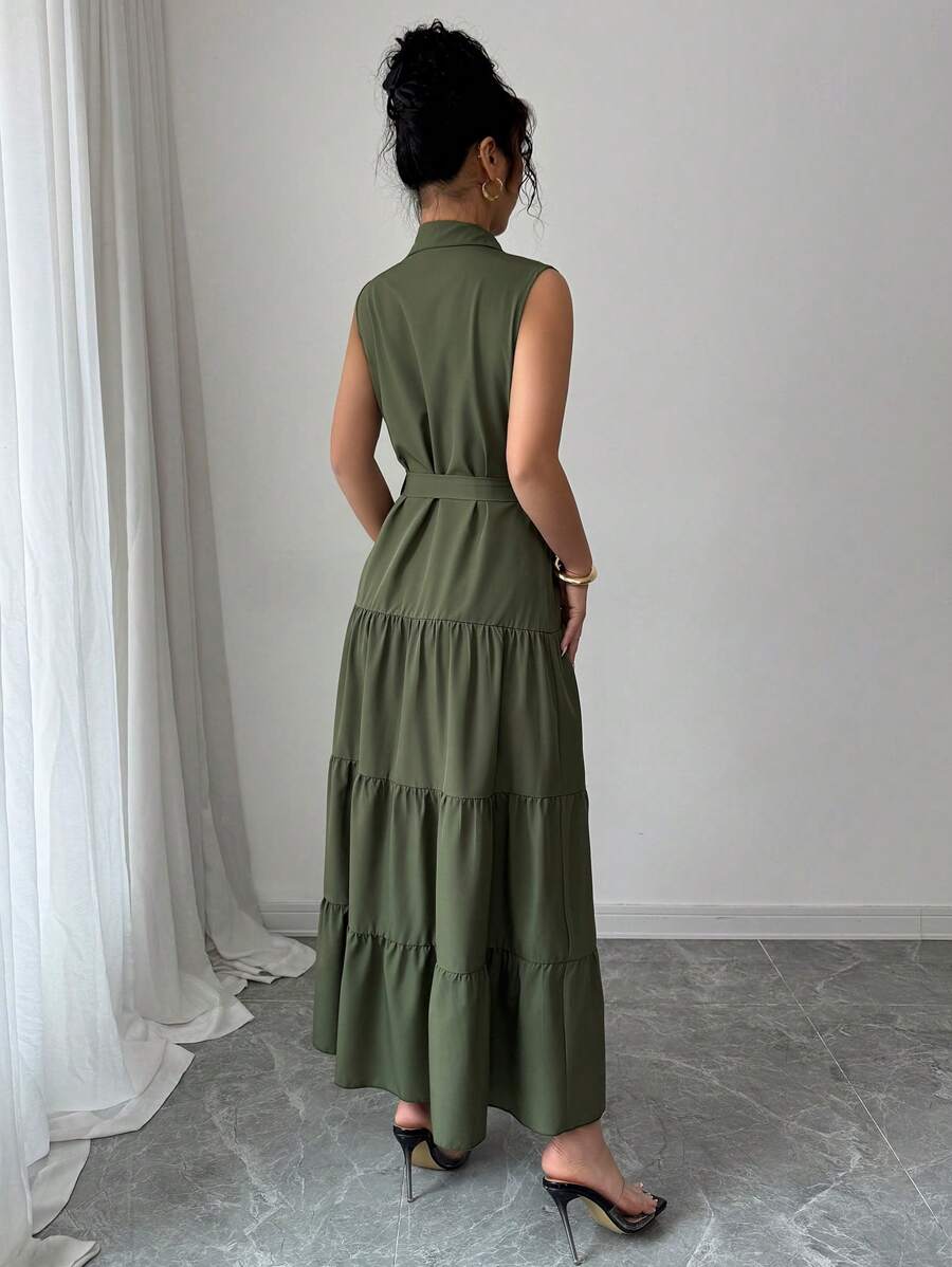 Mujer modelando un vestido camisero largo verde olivo sin mangas con cinturón.