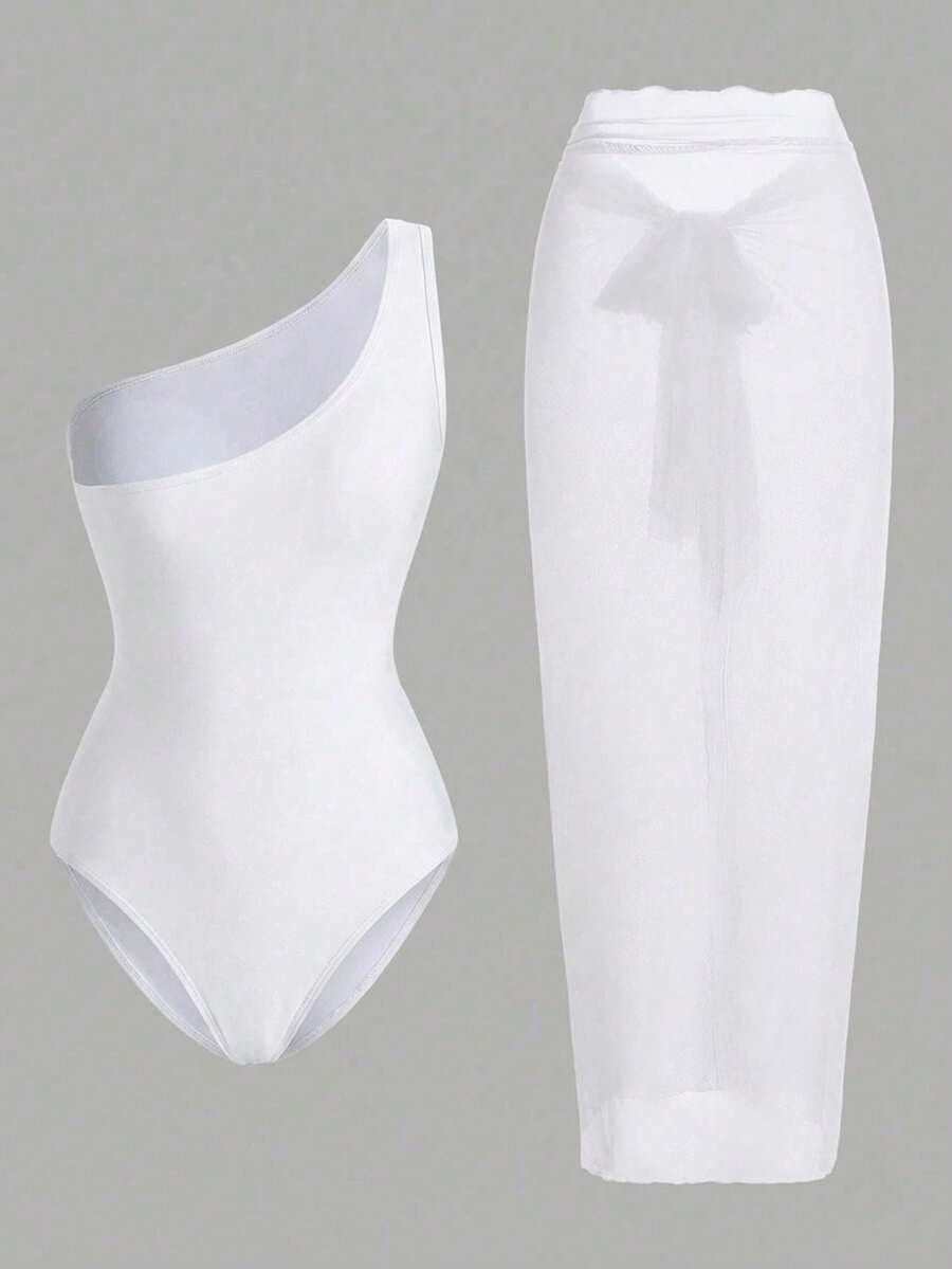 Vista completa de conjunto de baño blanco de dos piezas con body asimétrico y falda pareo.