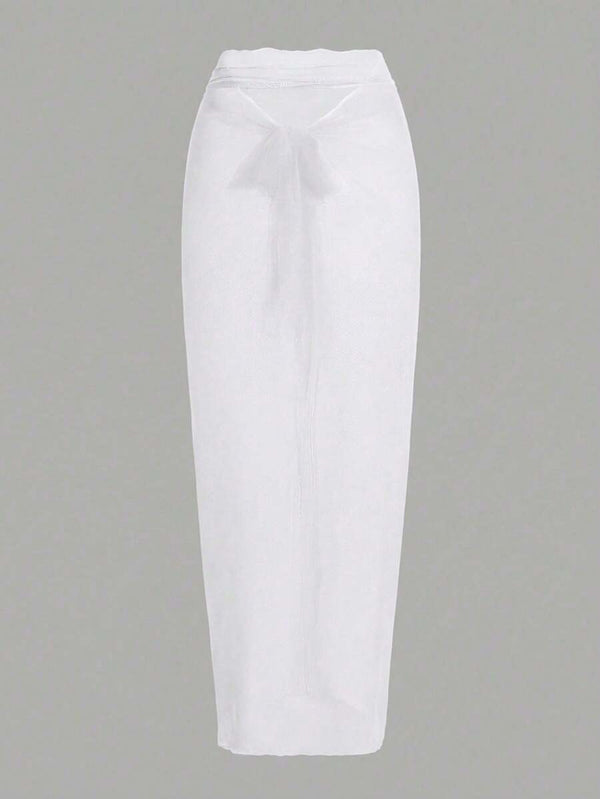 Primer plano de la falda larga tipo pareo con nudo frontal del conjunto de baño blanco.