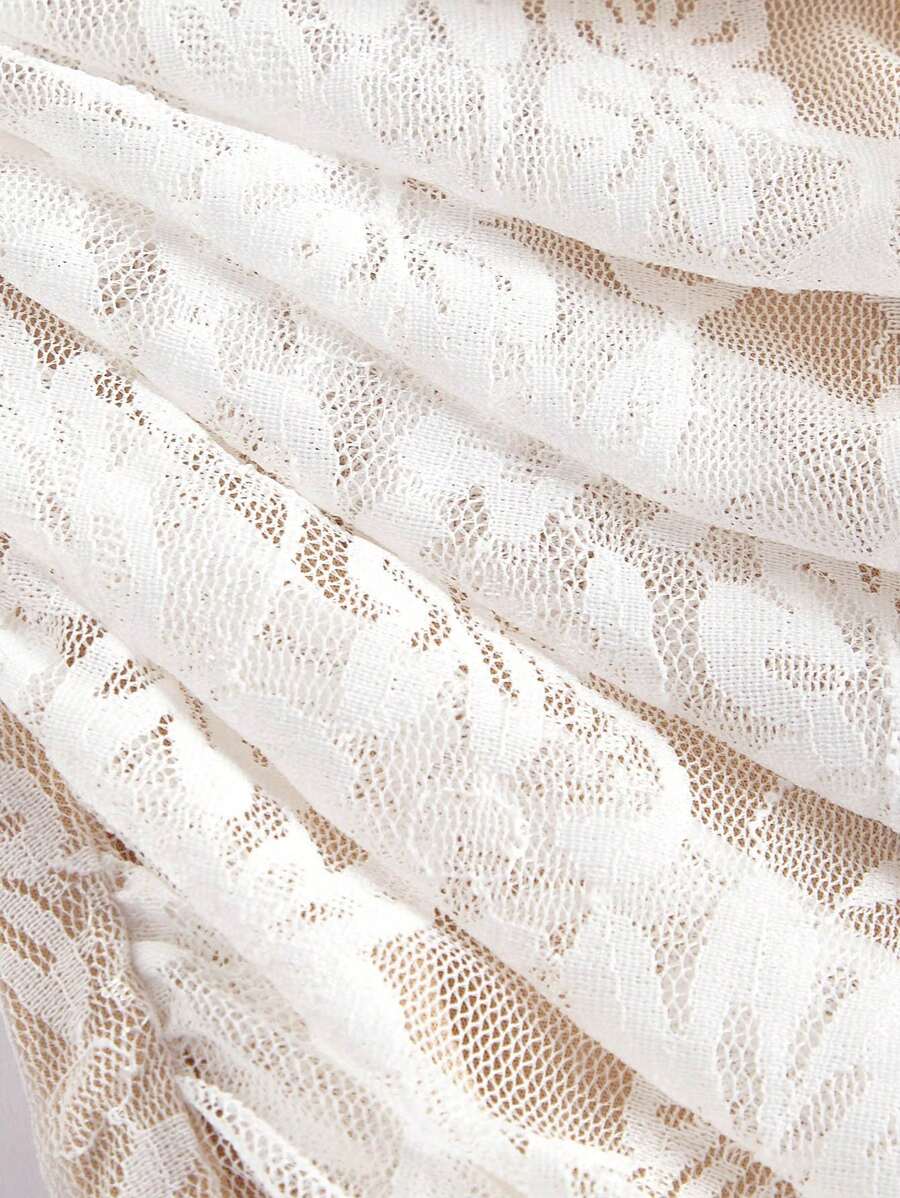 Mujer con curvas luciendo un vestido elegante de encaje blanco hueso con hombros descubiertos y cuerpo fruncido.