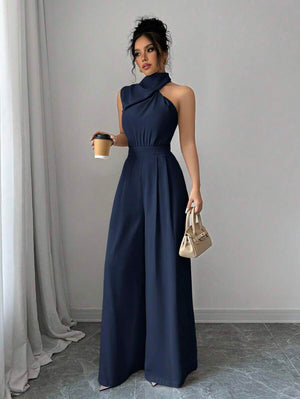 Detalle de la parte inferior de un jumpsuit palazzo azul marino mostrando la fluidez de la tela y los zapatos.
