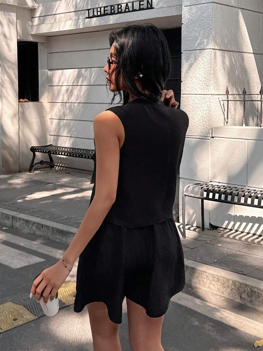 Conjunto blazer negro sin mangas con botones visto de frente.