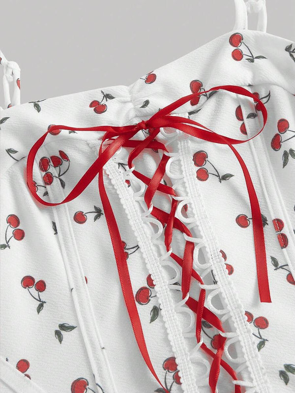 Vestido Blanco Corto Con Estampado De Cerezas detalle de cordones frontales.
