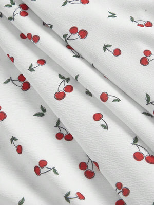 Vestido Blanco Corto Con Estampado De Cerezas tela con estampado frutal.