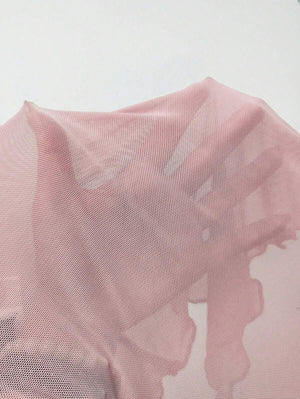 Detalle del escote cruzado en la espalda de un vestido rosa de fiesta con hombros descubiertos.