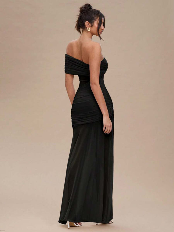 Primer plano del torso de una modelo luciendo un vestido negro con escote de un solo hombro.