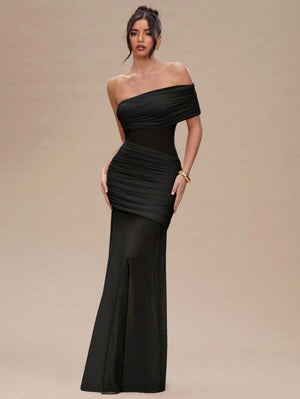 Detalle del diseño drapeado en la cintura de un vestido de noche negro ajustado.