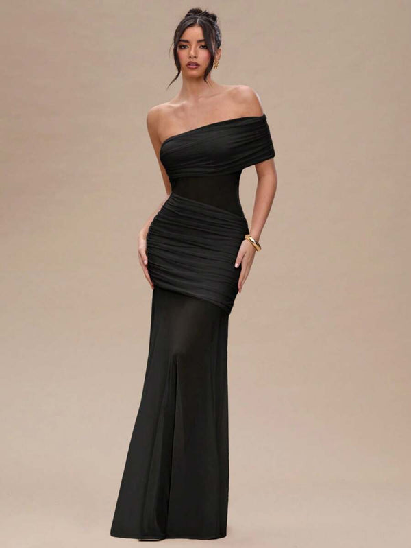 Detalle del diseño drapeado en la cintura de un vestido de noche negro ajustado.