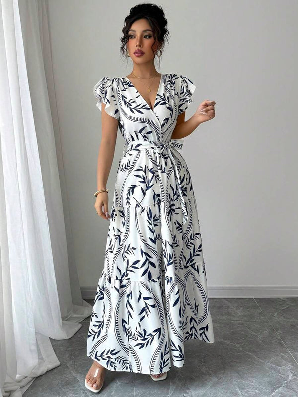 Modelo luciendo vestido largo bohemio azul y blanco con cinturón envolvente.