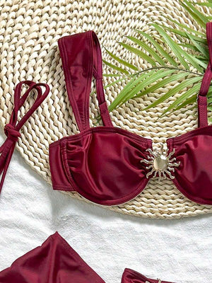 Conjunto completo de traje de baño de tres piezas vino tinto mostrando el top, la braguita y la falda con volantes.