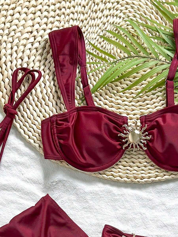 Conjunto completo de traje de baño de tres piezas vino tinto mostrando el top, la braguita y la falda con volantes.