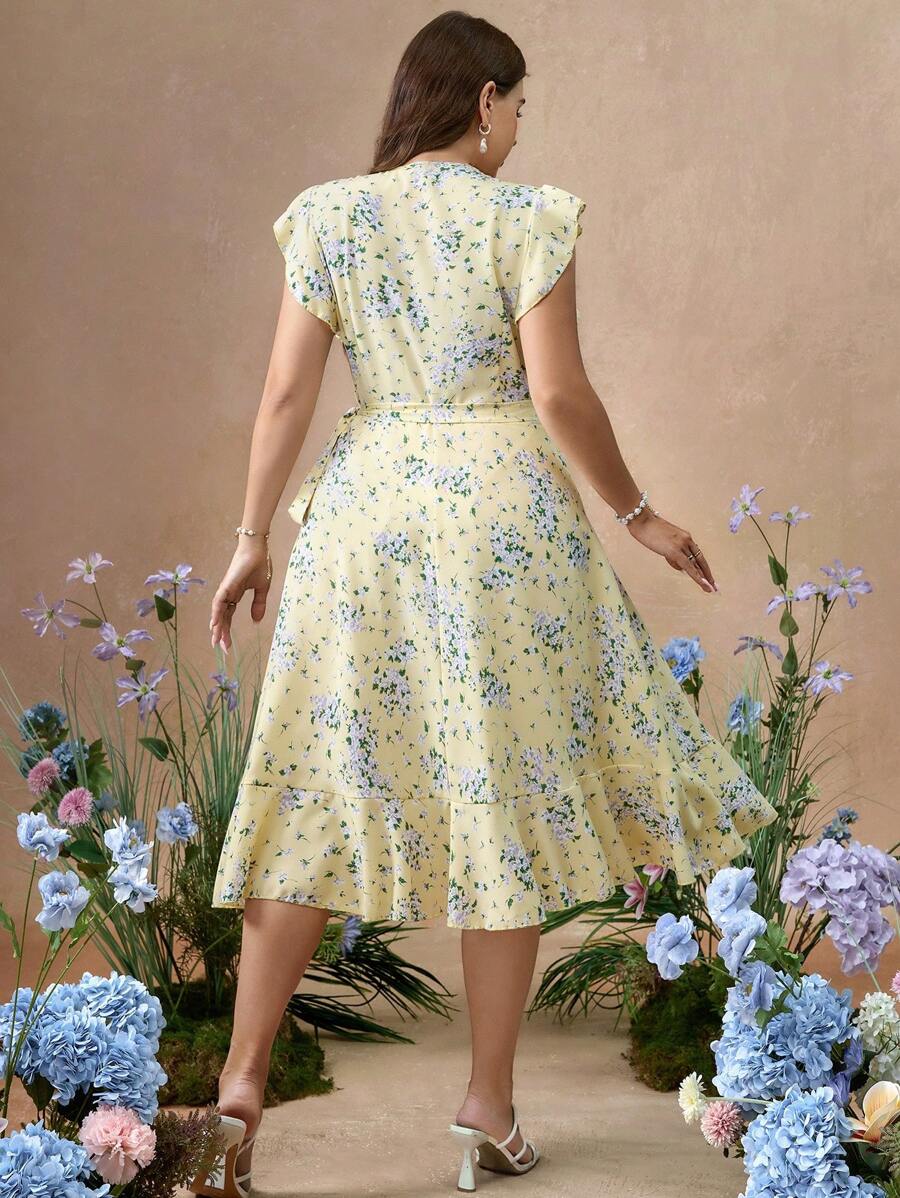 Vista frontal de un vestido cruzado amarillo con estampado floral y volantes.