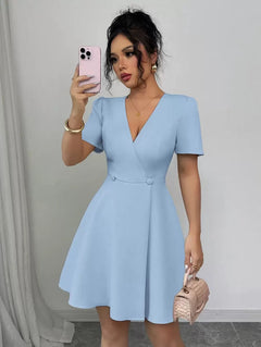 Vista frontal de una mujer usando un vestido corto azul cielo con escote en V y falda acampanada.
