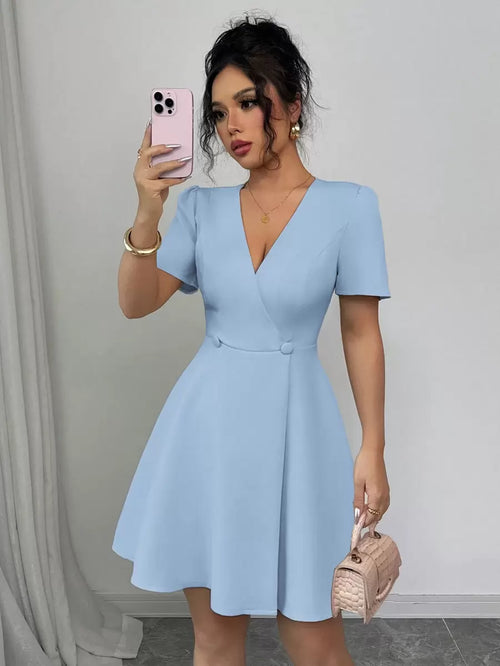 Vista frontal de una mujer usando un vestido corto azul cielo con escote en V y falda acampanada.