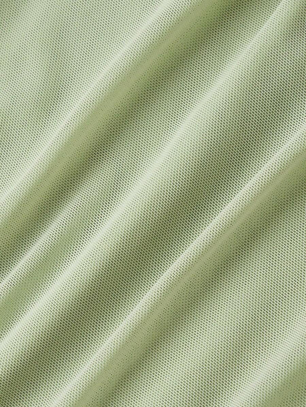Detalle de la parte superior de un vestido bodycon verde con fruncido y escote cuadrado.