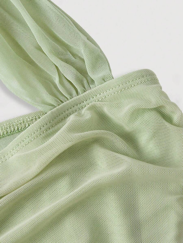 Vista inferior de un vestido midi estilo tubo de color verde claro, mostrando el detalle del fruncido en la falda.