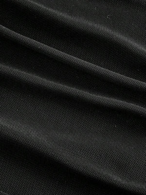 Detalle del tejido fruncido en la parte inferior de un vestido bodycon negro.