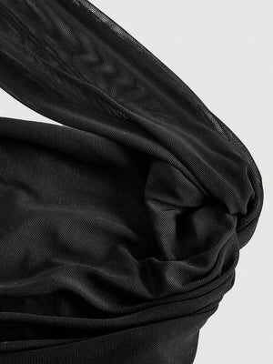 Silueta de vestido negro ajustado con diseño asimétrico y textura drapeada.