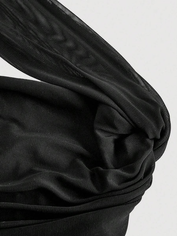 Silueta de vestido negro ajustado con diseño asimétrico y textura drapeada.