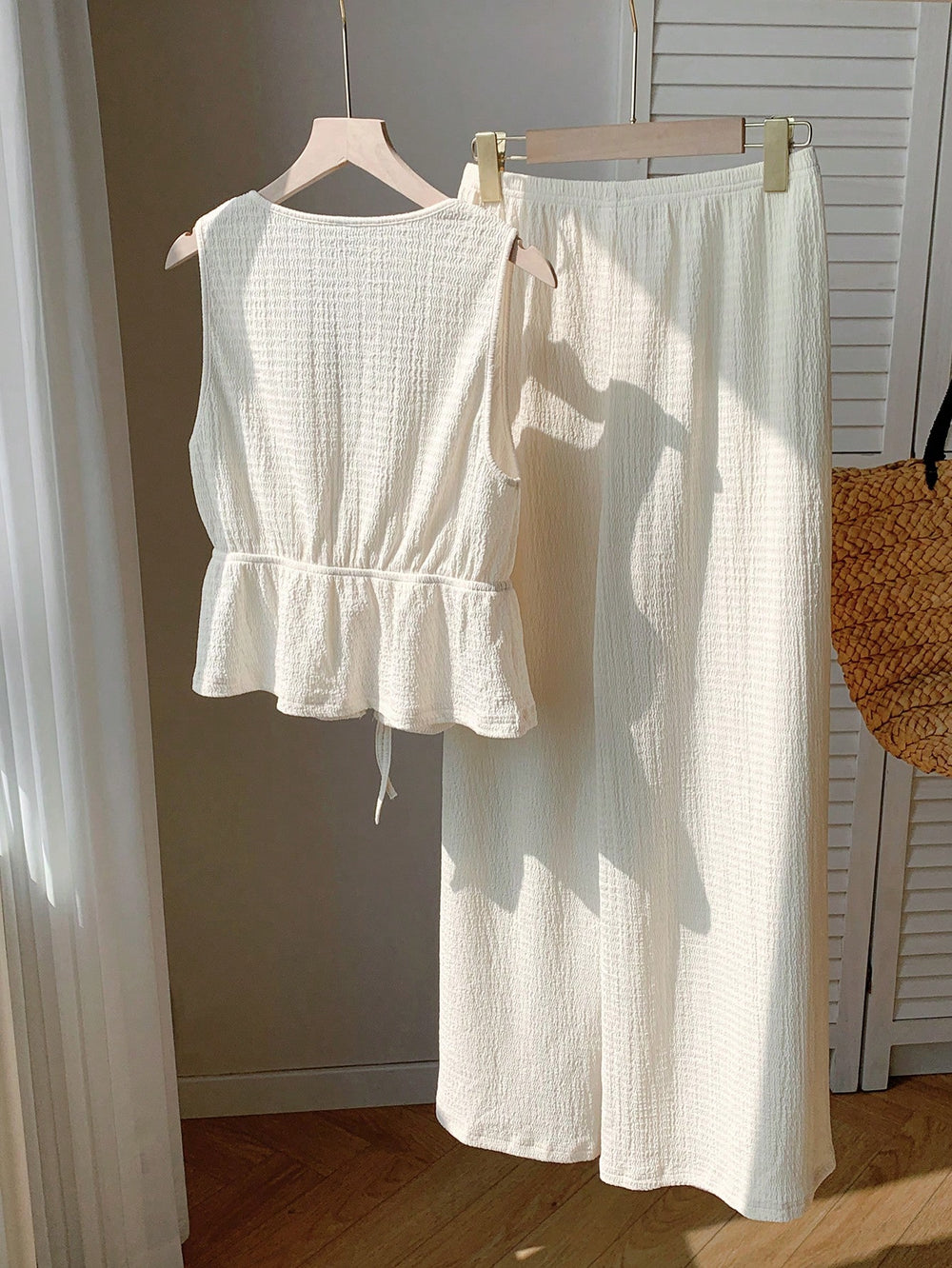 Conjunto de playa albaricoque con top anudado y pantalón largo sobre fondo claro.